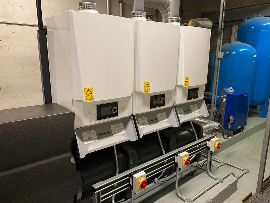 Row of commercial boilers with flue and pipework